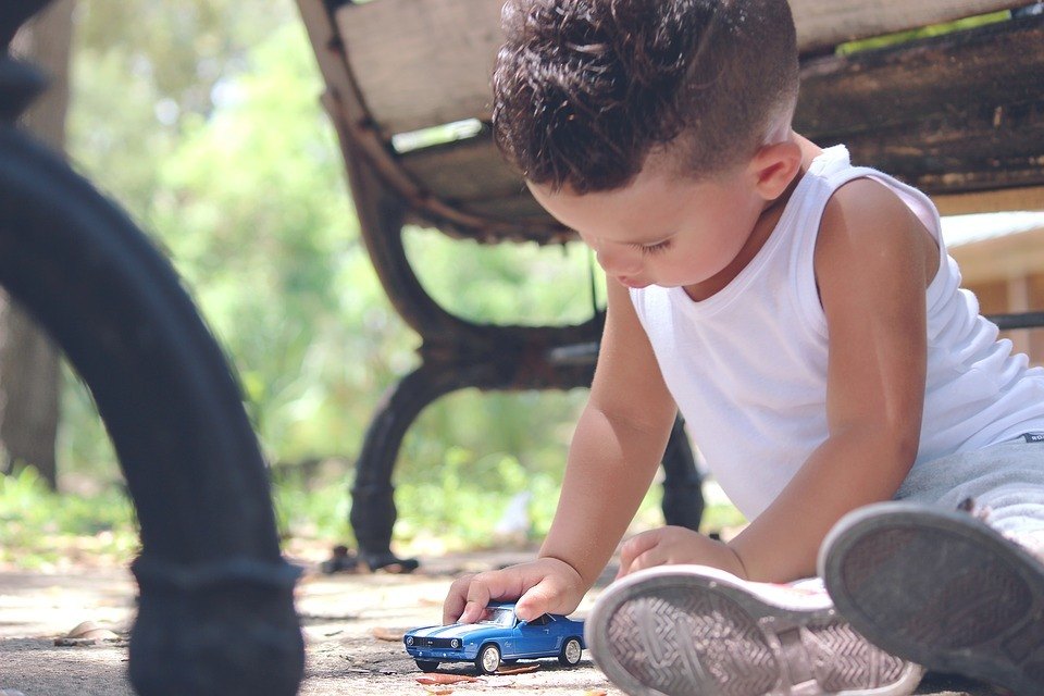 Kind spielt mit Spielauto Kind spielt mit Spielauto